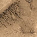 A l’intérieur de la dépression de Newton, d’étroits chenaux serpentent du sommet jusqu’au sol. Ces « ravines » et bien d’autres ont été observées pour la première fois sur des images haute résolution prises par Mars Global Surveyor.