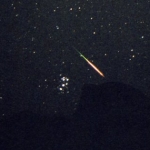 Une étoile filante des Perséides passant non loin de l'amas des Pléiades, en août 2004