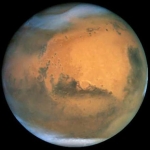 Cette image prise par Hubble une semaine avant la photo de Chandra montre Mars avec une résolution de 16 km. On y distingue parfaitement les tempêtes de poussières (au pôle nord, en bas à droite et tout au long du limbe) qui balayèrent la Planète Rouge pendant des mois. Les poussières projetées dans la haute atmosphère n’ont eu aucune incidence sur l’émission X de Mars.