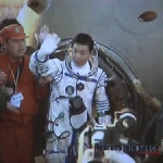 Yang Liwei sort de la capsule et salue l’équipe de récupération debout. Peu après, il sera placé sur une chaise, conformément aux procédures habituelles.