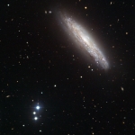 NGC 4666 et, dans le coin en bas à gauche, NGC 4688, se livrent un duel gravitationnel fratricide dont les étoiles, qui se forment à un rythme soutenu, sont les seules gagnantes