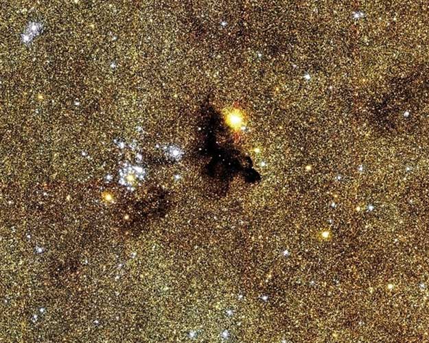 Les étoiles brillantes font partie de l\'amas ouvert NGC 6520 dans la voie lactée.
Ces étoiles très jeunes se sont formées il y a moins d\'un million d\'années, vraisemblablement en
partie grâce à la matière du nuage moléculaire Barnard 86. Ce nuage, tout noir sur l\'image,
très riche en poussières, est une nébuleuse par absorption. Il nous cache la lumière des étoiles en arrière plan.
