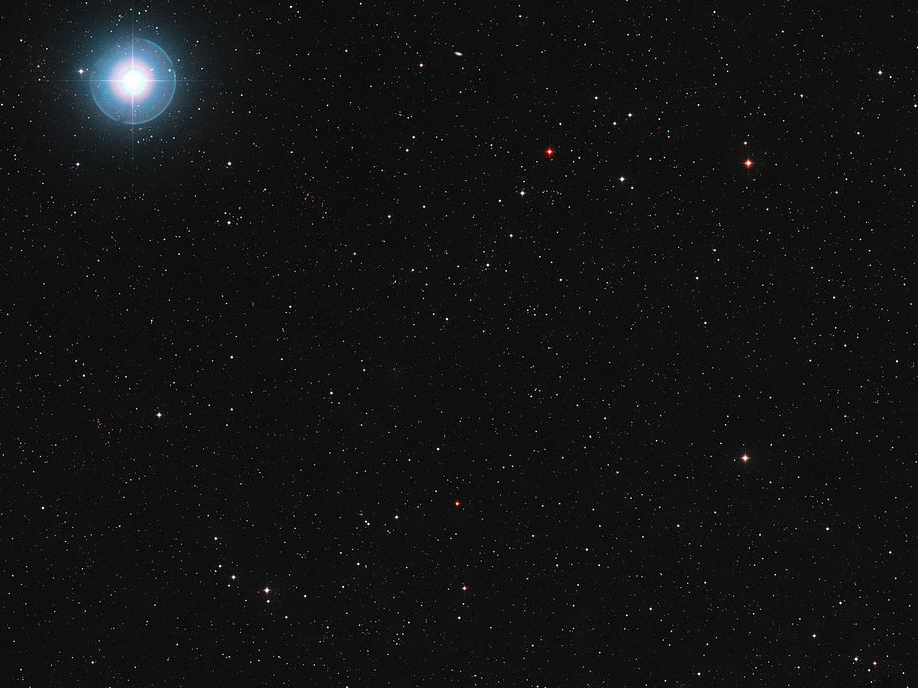 L\'étoile Ross 128 est la petite tête d\'épingle rouge rubis visible en bas et au centre de cette image. Nous savons aujourd\'hui qu\'elle est accompagnée d\'au moins une planète, Ross 128b L\'étoile Ross 128 est la petite tête d\'épingle rouge rubis visible en bas et au centre de cette image. Nous savons aujourd\'hui qu\'elle est accompagnée d\'au moins une planète, Ross 128b