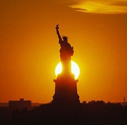 Le Soleil se couchant derrière la Statue de la Liberté est un peu plus lointain qu\'a l\'accoutumée le 4 juillet