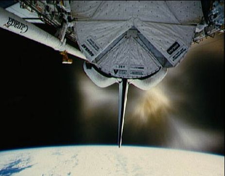 OMS, le système de manœuvre orbitale de la navette spatiale, vient de procéder à l\'allumage d\'un moteur tandis que de la navette se trouve la tête en bas, sa position normale de croisière en orbite basse.