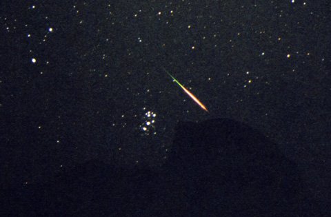 Une étoile filante des Perséides passant non loin de l\'amas des Pléiades, en août 2004