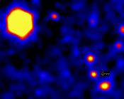 Qui veut gagner des milliards d’années-lumière ? Parmi ces sources lumineuses, le télescope Keck a surpris la lueur tardive du sursaut gamma GRB 971214. Saurez vous la reconnaître ? La grosse tache jaune en haut à gauche ? C’est votre dernier mot ? Joker… Elle est dans le chapelet de trois sources ponctuelles, en bas à droite, et c’est celle du milieu. Les sursauts gamma, répartis uniformément dans toutes les directions du ciel, ne sont jamais là où on les attend…