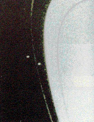 L\'anneau F, vu par la sonde Voyager 2. La structure de l\'anneau est irrégulière.
Il est entouré par les deux satellites Pandora et Promethée avec lesquels
il interagit.