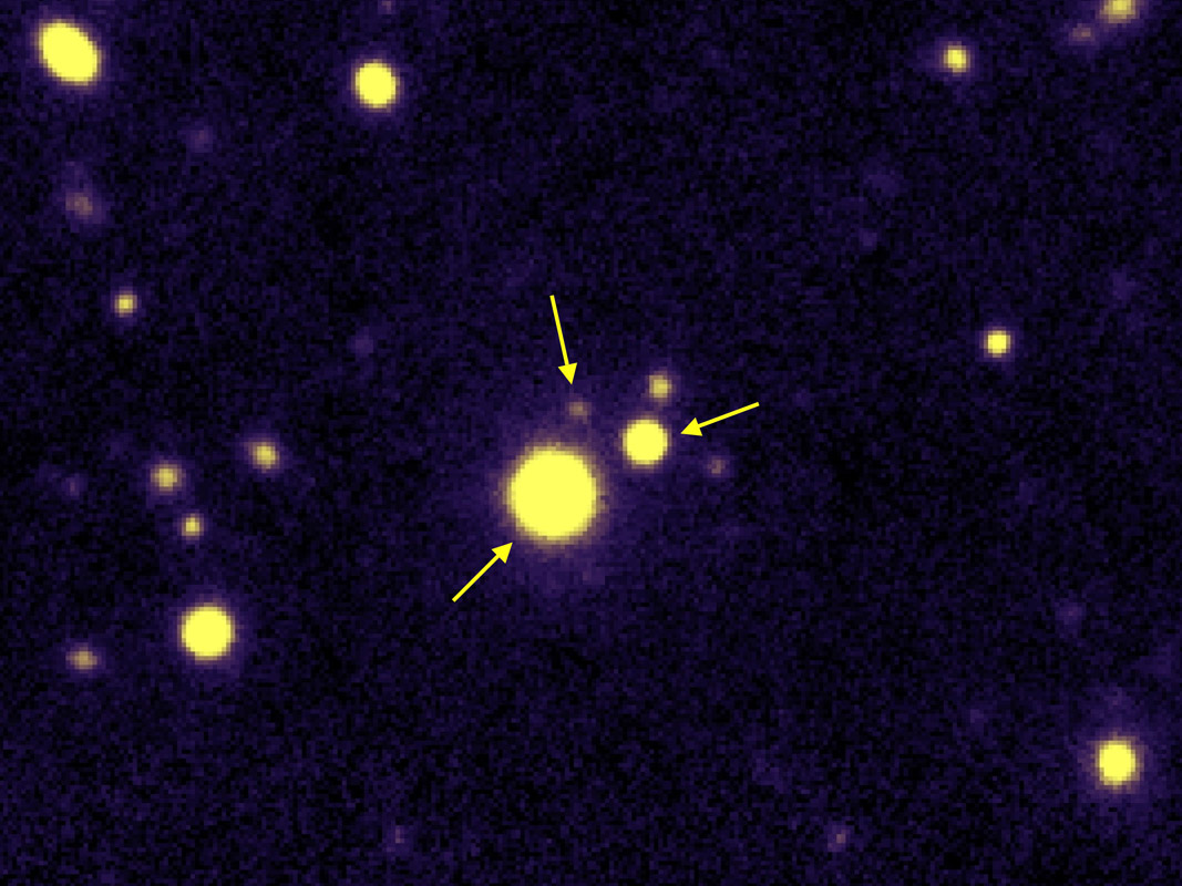 Image du quasar triple QQQ 1429-008, les trois quasars sont indiqués par les flèches. Image du quasar triple QQQ 1429-008, les trois quasars sont indiqués par les flèches.