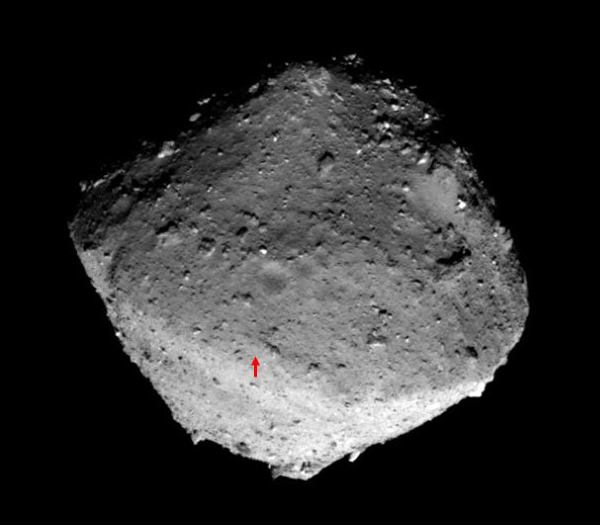 L\'hémisphère nord de l\'astéroïde Ryugu photographié le 24 janvier 2019, la flèche rouge désigne le site de contact